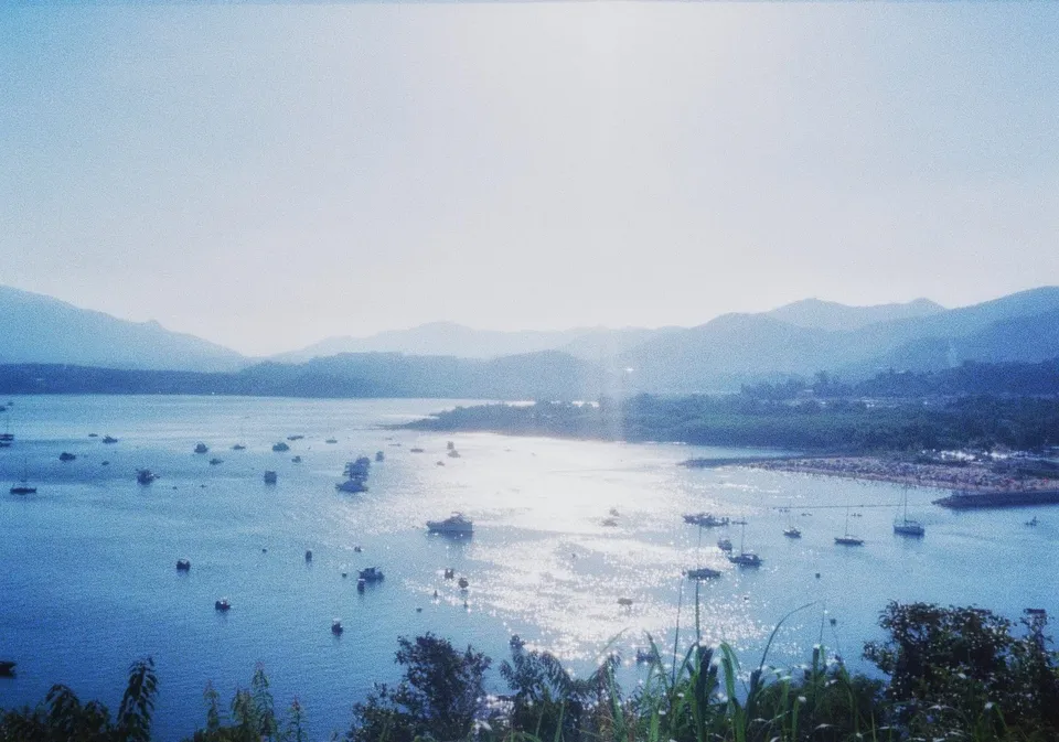 Water view with mountains behind, shooting directly at the sun