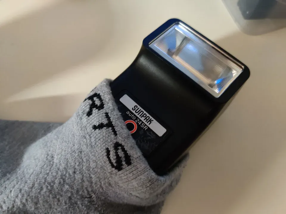Sunpak auto 24 SR flash unit half inside a sock
