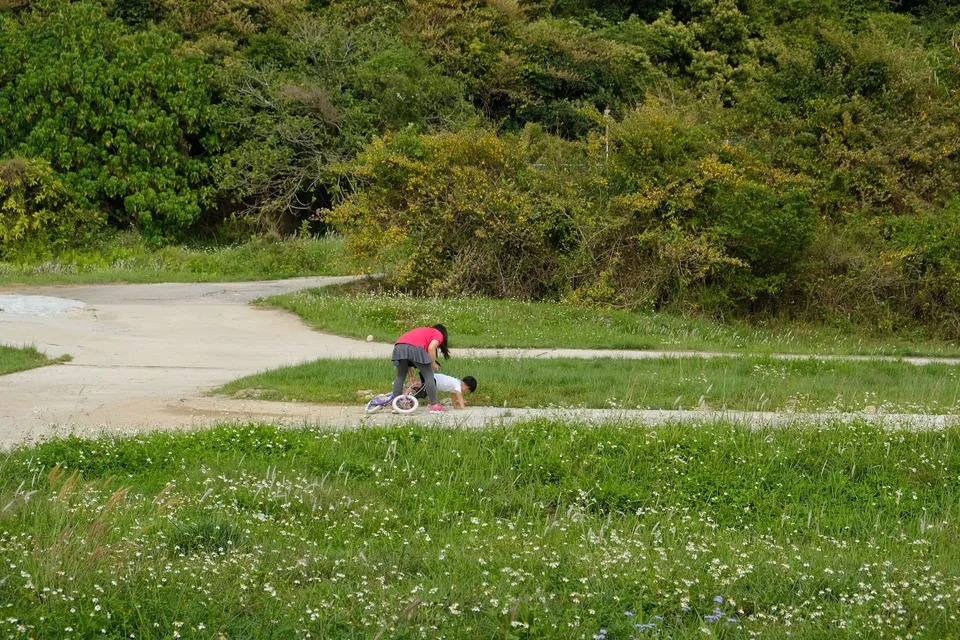 Mother picking up kid who fell from a bicycle