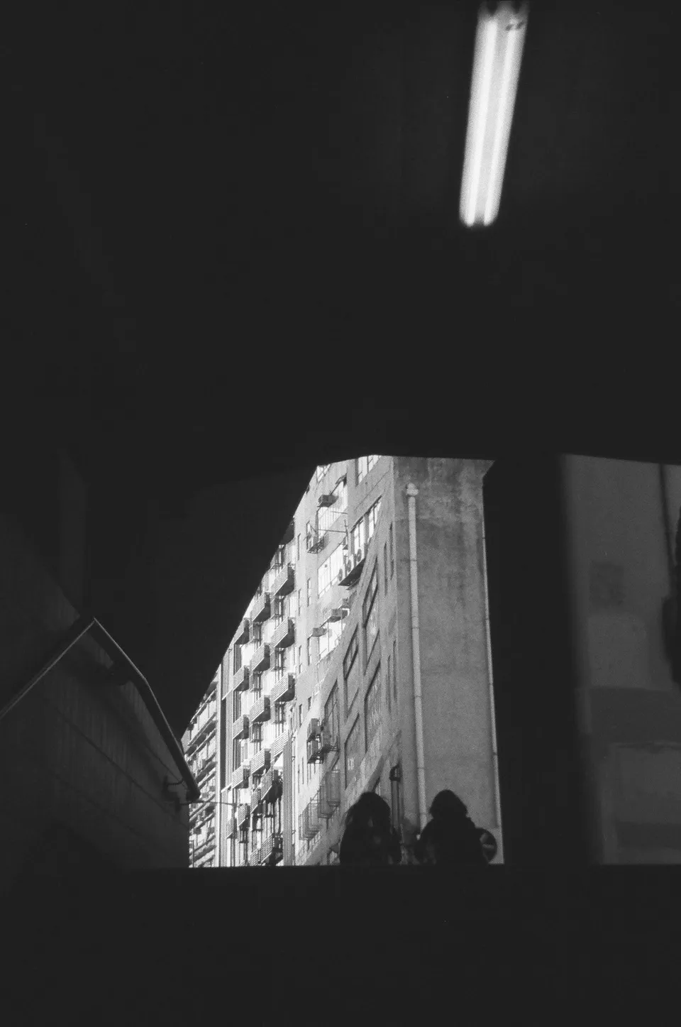 Black and white shot looking out of a pedestrian tunnel